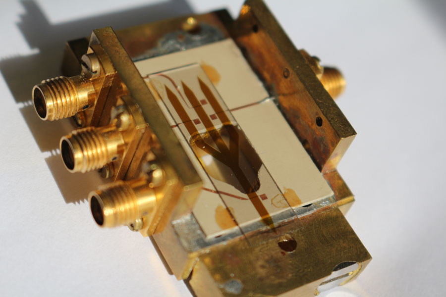 Full majority gate prototype. The brass block serves as an electric ground plate ensuring an efficient insertion of the RF currents to the antennae and, on the other hand, microwave connectors mounted to the block allow for the embedding of the device into our microwave setup. <br/>CREDIT: Fischer/Kewenig/Meyer Full majority gate prototype. The brass block serves as an electric ground plate ensuring an efficient insertion of the RF currents to the antennae and, on the other hand, microwave connectors mounted to the block allow for the embedding of the device into our microwave setup. Credit: Fischer/Kewenig/Meyer