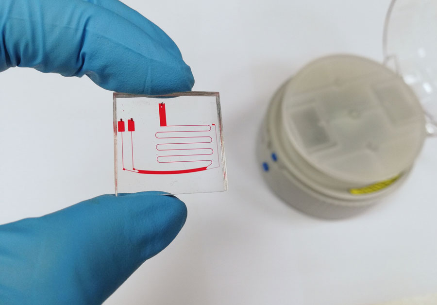 μCENSE chip with the benchtop centrifugal platform in the background. <br/>CREDIT: Joo Chuan Yeo μCENSE chip with the benchtop centrifugal platform in the background. Credit: Joo Chuan Yeo
