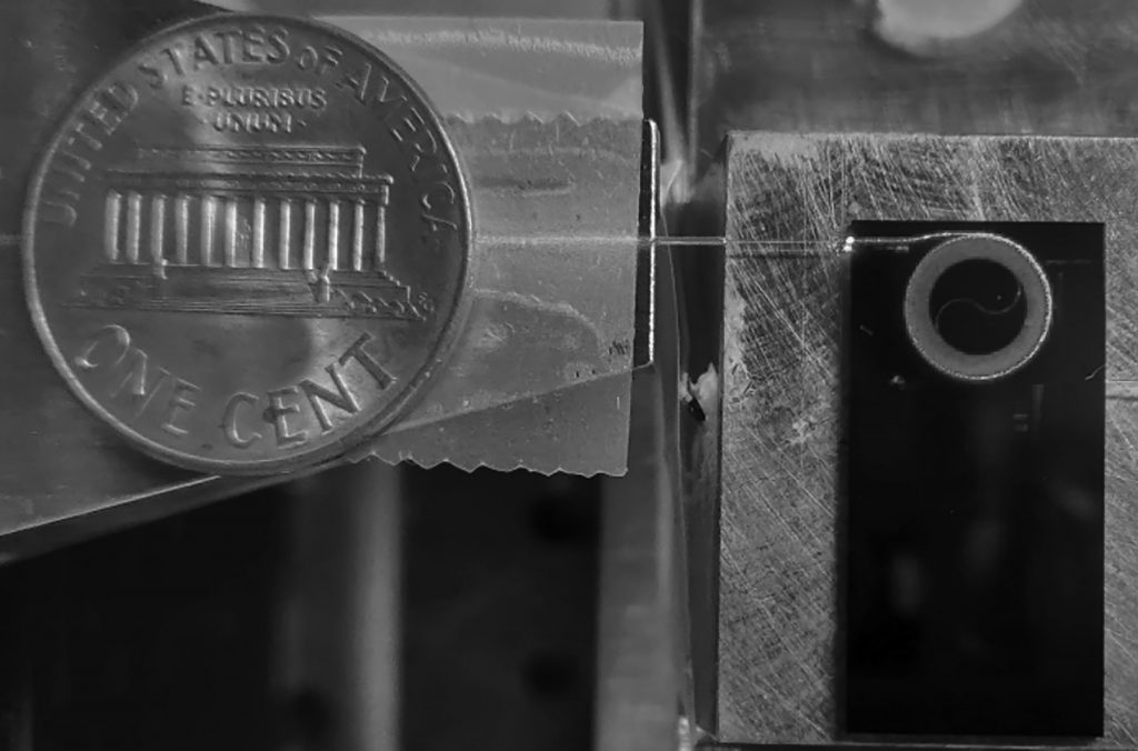 A photonic integrated circuit in which an ultralow loss 2-meter optical waveguide guiding visible light in the red spectrum is put on a silicon nitride chip smaller than a penny, important for applications such as strontium atomic clocks. CREDIT: Nitesh Chauhan and the DARPA MTO ApHI program